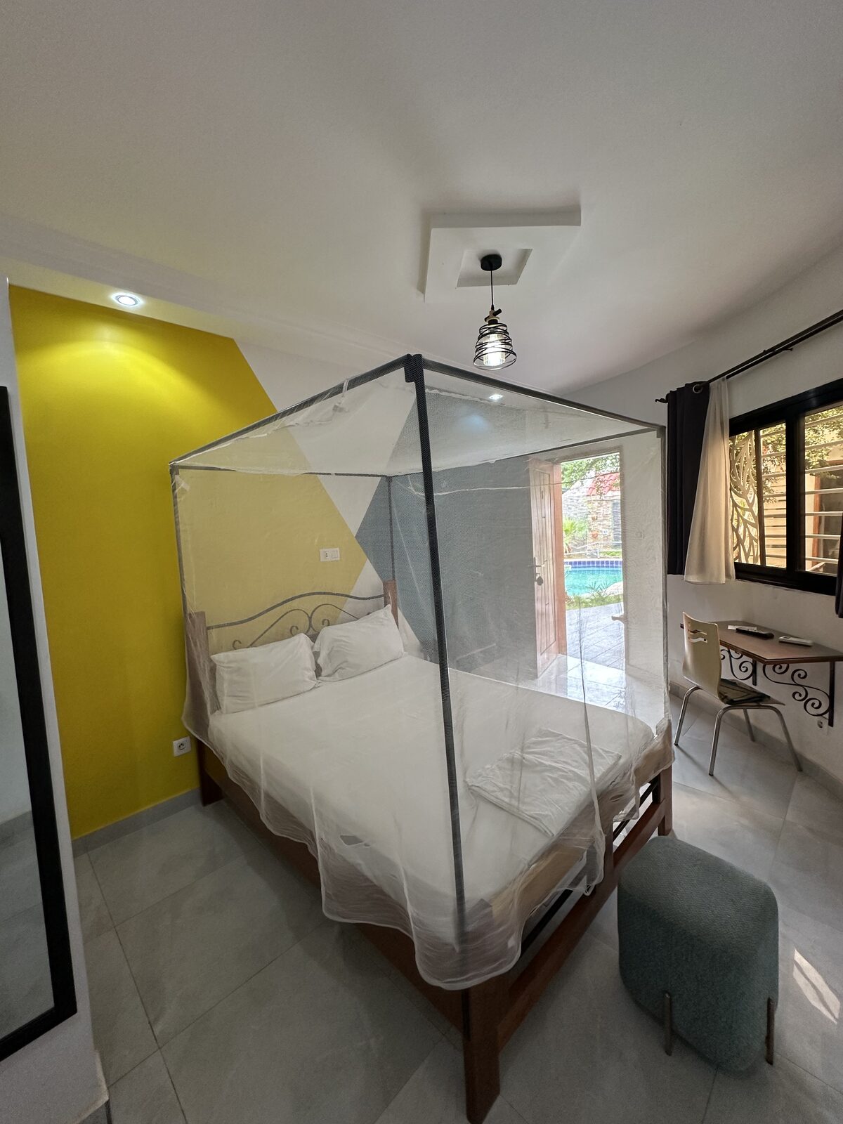 Chambre Simple, lit à moustiquaire, mur jaune et gris