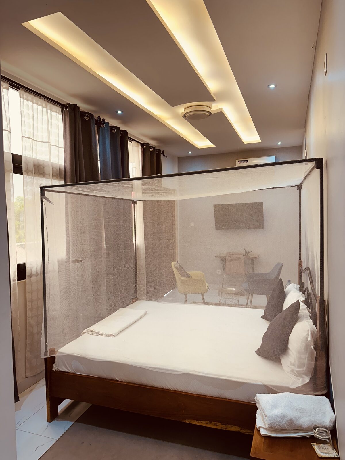 Chambre VIP, lit à moustiquaire en bois foncé